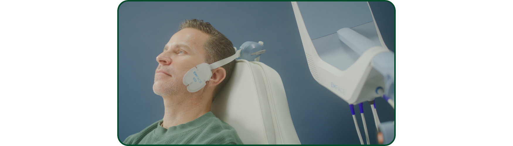 Patient receiving Emface facial treatment with applicators placed on the cheeks and forehead